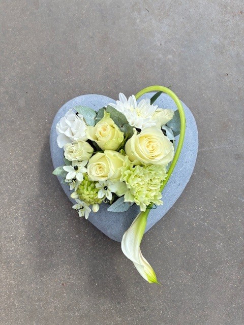 Bloemen in kleine hartvormige stenen schaal
